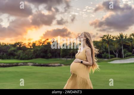 Ruhige Szene, in der eine schwangere Frau friedliche Momente im Park genießt, die Ruhe der Natur genießt und während ihrer Schwangerschaft Trost findet Stockfoto