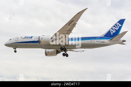 Ein Passagierflugzeug mit verlängertem Fahrwerk, das durch den Himmel fliegt Stockfoto