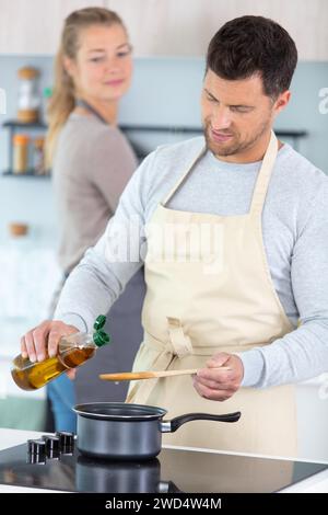 Blick auf Paare, die Pizza zuhause zubereiten Stockfoto