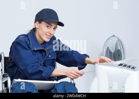 Klempnerin Baumeister in Rollstuhlheizungsanlage Stockfoto