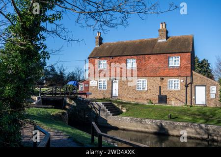 Stoke Lock und Cottage am Fluss Wey & Navigations in der Nähe von Guildford, Surrey, England, Großbritannien, an einem sonnigen Wintertag Stockfoto