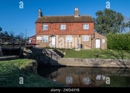 Stoke Lock und Cottage am Fluss Wey & Navigations in der Nähe von Guildford, Surrey, England, Großbritannien, an einem sonnigen Wintertag Stockfoto