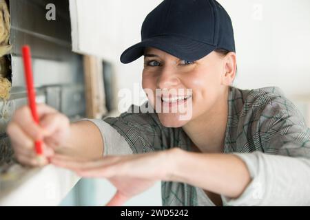 Weibliche Arbeiterin, die etwas auf der Arbeit markiert Stockfoto