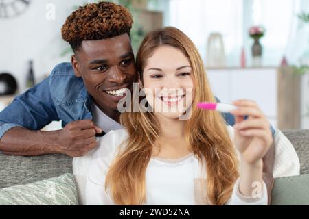 Glückliches Paar, das Ergebnisse eines Schwangerschaftstests herausfindet Stockfoto