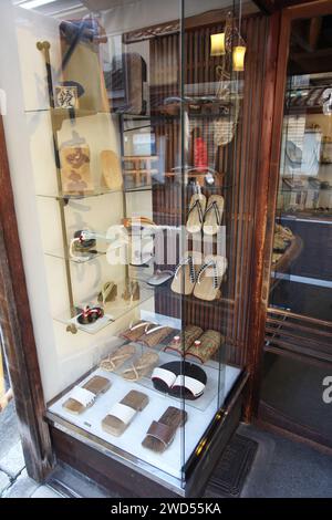 Eine Ausstellung von Geta oder traditionellen japanischen Sandalen in einem Glasschrank in einem alten Schuhgeschäft in der Yamatooji Street in Gion, Kyoto, Japan. Stockfoto