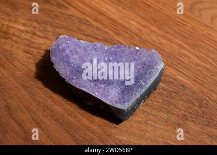 Schöne Fliedertrommel mit Amethyst-Kristallen auf hölzernem Hintergrund. Magische Halbedelsteine. Stockfoto