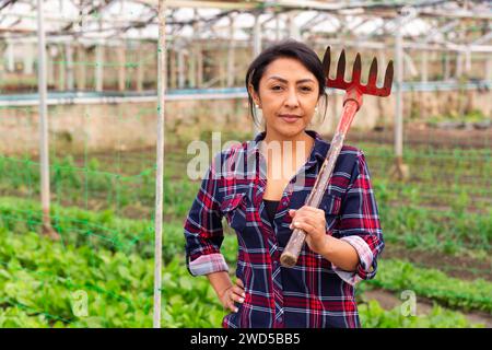Gärtnerin, die mit Rechen steht Stockfoto