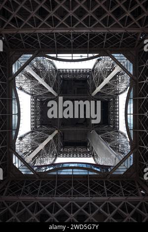 Blick von unten auf die beeindruckende Metallkonstruktion, Eiffelturm, von unten gesehen, Mausperspektive, Geometrie, Füße von Touristen auf Glas Stockfoto