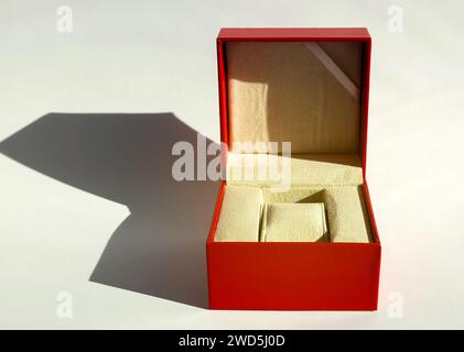 Ein geöffnetes rotes Uhrenfeld auf weißem Hintergrund. Aufbewahrungsbox für Armbanduhren. Geschenkkonzept für Männer. Stockfoto