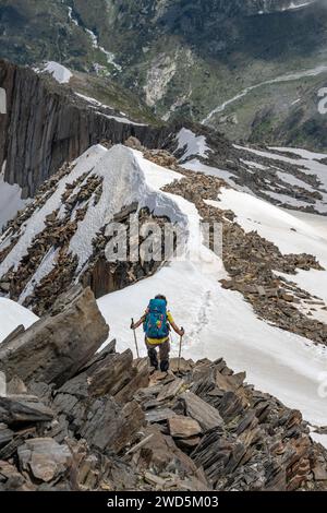 Bergsteiger auf einem schneebedeckten felsigen Bergrücken, Abfahrt vom Gipfel des Schönbichler Horns, Berliner Hoehenweg, Zillertaler Alpen, Tirol, Österreich Stockfoto