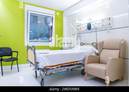 Leerraum eines Krankenhausraumes mit Bett und Stühlen Stockfoto