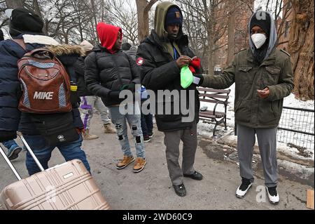 New York, USA. Januar 2024. Asylsuchende Migranten, meist aus Westafrika, versammeln sich im Tompkins Square Park außerhalb der St. Brigid Pensionierungszentrum auf der Lower East Side in Manhattan, New York, NY, 18. Januar 2024. Migranten warten auf eine neue Unterbringung, nachdem vor kurzem eine Begrenzung von 30 Tagen auferlegt wurde, was sie zwingt, sich erneut zu bewerben und abzuwarten; Schätzungen zufolge kommen wöchentlich etwa 3000 Migranten in New York City an. (Foto: Anthony Behar/SIPA USA) Credit: SIPA USA/Alamy Live News Stockfoto