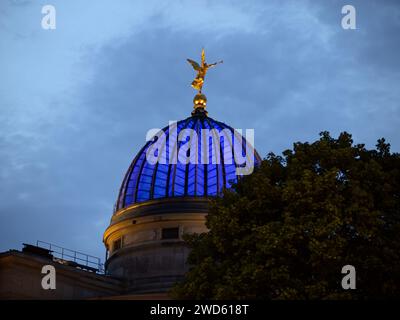 Kuppel der Akademie der Schönen Künste in blauer Farbe bei Nacht. Eine goldene Engelskulptur befindet sich auf dem historischen Gebäude. Stockfoto