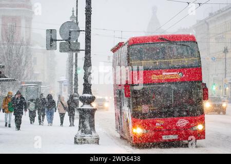 St. Petersburg, Russland. Januar 2024. Ein roter Touristenbus steht an einer Bushaltestelle in der Nähe der U-Bahn-Station Gostiny Dvor während eines Schneefalls im Zentrum von St. Petersburg. (Foto von Artem Priakhin/SOPA Images/SIPA USA) Credit: SIPA USA/Alamy Live News Stockfoto