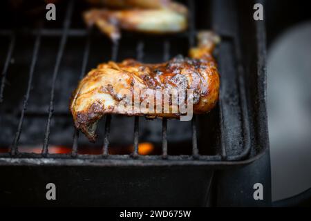 Barbeque Pit Hähnchenschenkel und Oberschenkel bedeckt mit BBQ-Sauce und Gewürzen und hausgemachter würziger Sauce mit Geschmack der Karibik Stockfoto