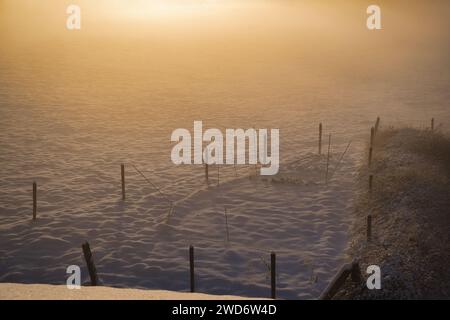 Ein malerischer Blick auf ein schneebedecktes Feld bei Sonnenuntergang in Maransart, Belgien Stockfoto