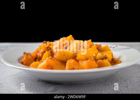 Hackfleisch und Kartoffelschale auf weißem Porzellanteller auf Steintisch Stockfoto