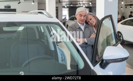 Ein älteres kaukasisches Paar wählt ein neues Auto in einem Autohändler. Stockfoto