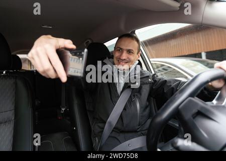 Ein fröhlicher indianer, der Auto fährt, vom Armaturenbrett erschossen wird, während der Sommerferien auf Reisen geht, Kopierraum. Ein glücklicher Typ aus dem Nahen Osten in lässigen Outfits und Stockfoto