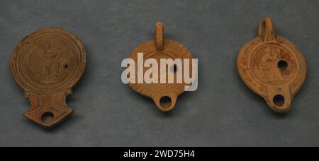 Römische Lampen mit Tonöl. Die links und rechts sind mit einer Darstellung einer Muse verziert. Die zentrale zeigt Selene. Nationalmuseum Für Archäologie. Lissabon, Portugal. Stockfoto