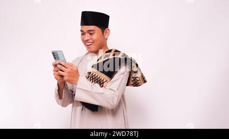 Videoanruf des asiatischen muslimischen Mannes auf dem Smartphone. Isoliert auf weißem Hintergrund Stockfoto