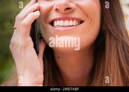 Nahaufnahme glückliche Geschäftsfrau, die draußen auf dem Smartphone spricht. Stockfoto