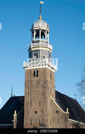 Turm der reformierten Kirche mit einer achteckigen Laterne, überragt von einem runden Kuppeldach und einer Uhr in der Mitte des Dorfes Lemmer mit blauem Himmel Stockfoto