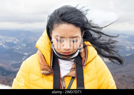 Eine junge Frau auf dem windigen Berg Stockfoto