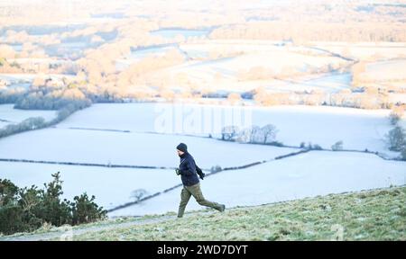 Brighton UK 19. Januar 2024 - Ein Läufer genießt einen schönen frostigen Morgen am Devils Dyke entlang des South Downs Way nördlich von Brighton, aber für die nächsten Tage wird mildes Wetter in Großbritannien prognostiziert: Credit Simon Dack / Alamy Live News Stockfoto