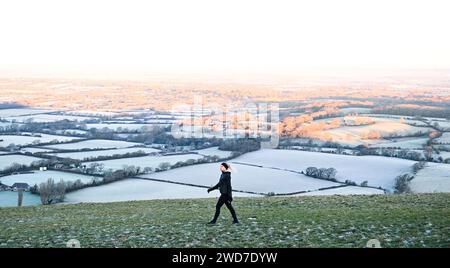 Brighton UK 19 Januar 2024 - Ein Läufer hält an um die Aussicht am Devils Dyke entlang des South Downs Way nördlich von Brighton an einem weiteren frostigen Morgen zu genießen aber mildes Wetter wird für die nächsten Tage in Großbritannien prognostiziert : Credit Simon Dack / Alamy Live News Stockfoto