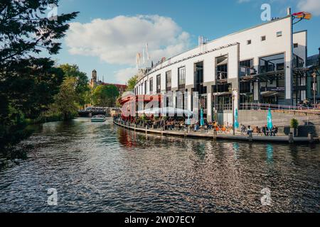 Ein malerischer Blick auf wunderschöne Gebäude entlang eines Flusses in Amsterdam, Niederlande Stockfoto