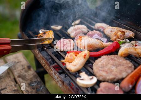 Verschiedene köstliche gegrillte Fleisch mit Gemüse über den Kohlen auf einem Grill Stockfoto