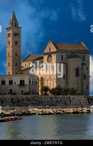 Von Osten aus gesehen, die Cattedrale di San Nicola Pellegrino oder Basilica cattedrale di Santa Maria Assunta, eine romanisch-apulische Kathedrale, die 1099 in Trani an der Adriaküste in Apulien (Apulien), Italien, begonnen wurde. Das hohe campanile der Kathedrale stammt aus den 1200er Jahren Der achteckige Glockenturm und der Turm stammen aus den Jahren 1353 bis 1365. Stockfoto