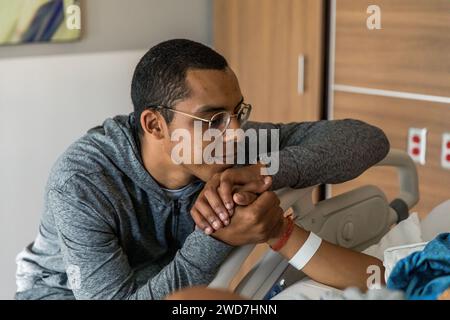 Afroamerikaner hält die Hand der Frau während der Geburt Stockfoto