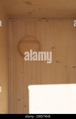 Ein Holzinnenraum mit einer Schüssel und einem Spiegel, der neben einem Waschbecken in der Sauna aufgestellt ist Stockfoto