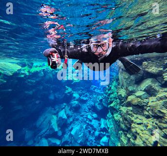 Der Mensch schnorchelt durch den Gletscherwasserschlucht Stockfoto