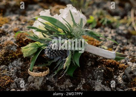 Detaillierte Nahaufnahme von Boutonniere und goldenem Ehering des Bräutigams Stockfoto