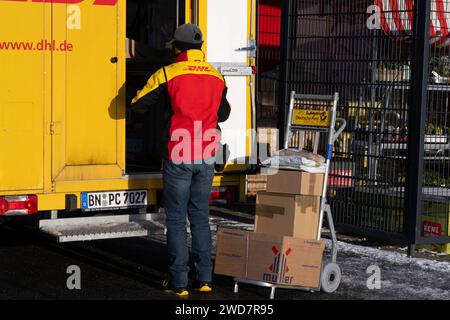 Lieferdienst in Aktion: DHL-Zusteller bereitet Paketlieferung bei REWE vor. , Deutschland, Rheinland-Pfalz, Speyer, 19.01.2024, auf dem Foto ist ein DHL-Zusteller zu sehen, der neben einem offenen, gelben Lieferwagen steht und Pakete auf einem Transportwagen vor sich hat. Im Hintergrund ist ein REWE-Schild erkennbar, was darauf hinweist, dass die Lieferung in der Nähe eines REWE-Supermarktes stattfindet. *** Zustelldienst in Aktion DHL-Zustellfahrer bereitet Paketzustellung bei REWE, Deutschland, Rheinland-Pfalz, Speyer, 19 01 2024 vor, das Foto zeigt einen DHL-Zustellfahrer, der neben einem steht Stockfoto