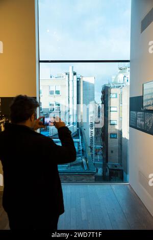 Blick von der Fotografen Galerie Ausstellung. Fotos im Zimmer auf der höheren Etage und der Schriftzug „Soho Photography Quarter“ auf dem Gebäude. London. UK. (137) Stockfoto