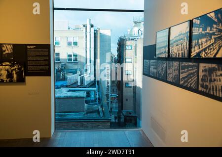 Blick von der Fotografen Galerie Ausstellung. Fotos im Zimmer auf der höheren Etage und der Schriftzug „Soho Photography Quarter“ auf dem Gebäude. London. UK. (137) Stockfoto