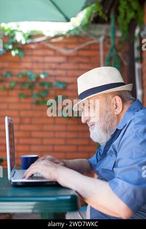 Älterer Mann mit Laptop im Freien Stockfoto