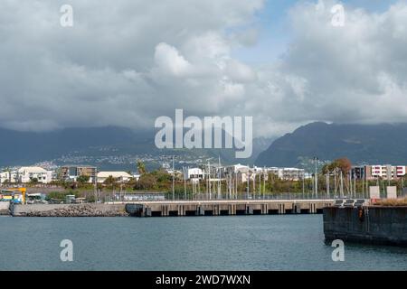 Blick auf den Hafen in der Stadt Le Port, in der Nähe von La Possession, Insel Reunion. Im Hintergrund ist der Cirque de Mafate zu sehen. Stockfoto