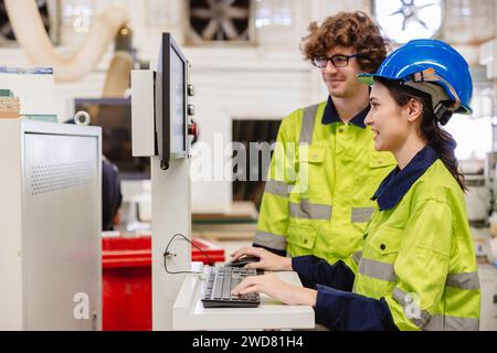 Mitarbeiter des Ingenieurteams, die in der Steuerung der Holzmöbelfabrik arbeiten, bedienen die Holzschneidemaschine Stockfoto