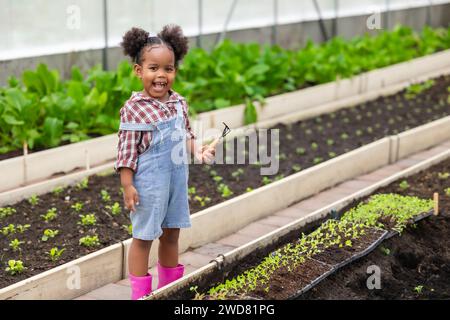 Afrikanisches schwarzes Kind beim Pflanzen des grünen Baumes in der Landwirtschaft. Kinder lieben das Naturkonzept. Stockfoto