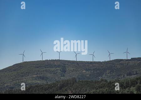 Berglandschaft mit Windturbinen auf den Bergen an einem schönen Tag mit blauem Himmel. Stockfoto