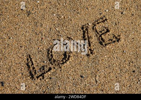 Liebe eingebettet in den Sand der Gelassenheit, ein ruhiger Strandmoment, der romantisches Flüstern am Ufer fängt Stockfoto