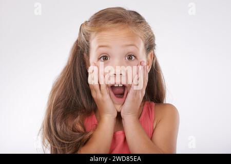 Mädchen, Kind mit Gesicht und Überraschung, Schock im Studio mit Reaktion oder Gesichtsausdruck auf Drama und Klatsch. Wow, Emoji und Angst mit Geschichte, Info oder Stockfoto