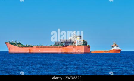 Frachtverkehr zwischen FPSO-Tanker und Versorgungsschiff im blauen Meer an einem ruhigen, sonnigen Tag mit klarem blauem Himmel. Stockfoto