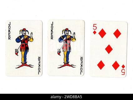Alte Spielkarten, die ein Paar Joker und eine rote fünf auf weißem Hintergrund zeigen. Stockfoto