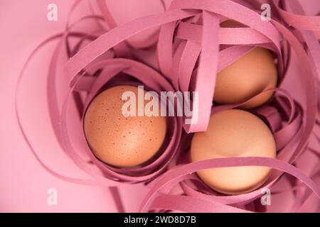 Frohe Ostern. Nahaufnahme von drei Eiern, die in farbige Bänder gewickelt sind. Fragilität und Schutzkonzept. Stockfoto